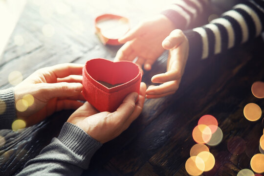 Woman holding hands with red heart on wooden background, top view - Powered by Adobe
