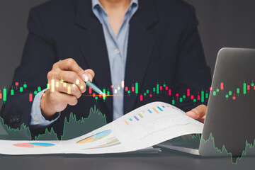 Businessman analyzing financial data and stock market chart.