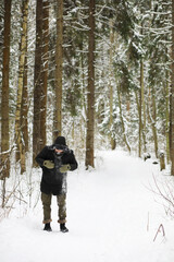 Bearded man in the winter woods. Attractive happy young man with beard walk in the park.