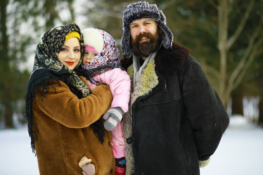 Traditional Russian holiday in early spring. Seeing off winter. Mardi gras. Family with children in the winter in the park.