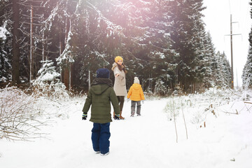 Happy family playing and laughing in winter outdoors in the snow. City park winter day.