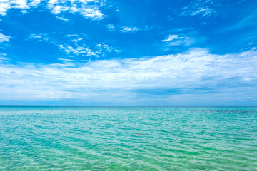 Aerial view of a background image for a summer vacation concept. Nature, beach and sea, sunny summer, sparkling seawater contrasting with a blue sky.