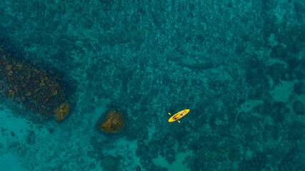 Aerial view of a kayak in the blue sea .man kayaking he does water sports activities.	