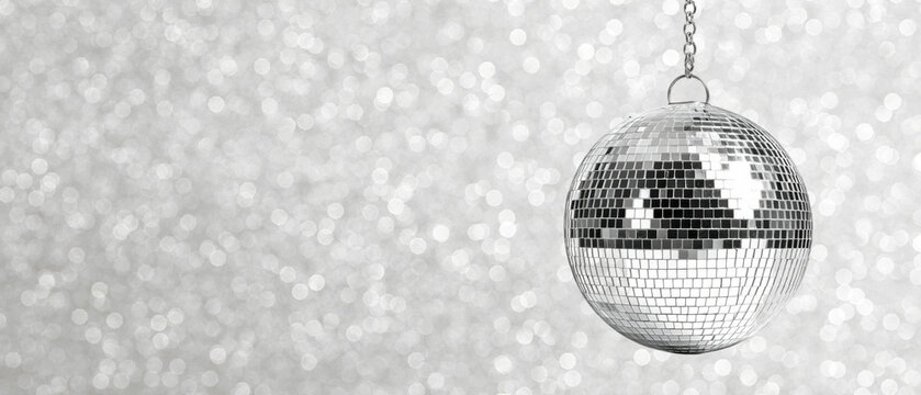 Disco ball gleams against a silver backdrop, created AI