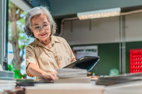 Senior Female Business Owner Inspecting Ceramics
