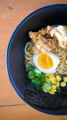 Delicious Ramen Bowl with Fried Chicken, Egg, and Vegetables on Wood Table