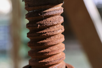 Macro close up view of an old rusty metal screw with industrial texture. Brown corrosion and...