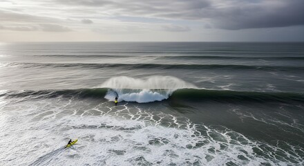An epic aerial perspective of a lone surfer riding a massive, powerful ocean wave under a dramatic, stormy sky