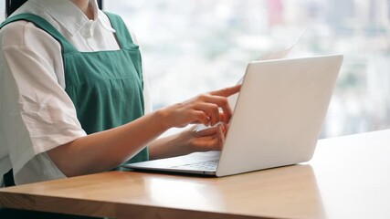 ノートパソコンでデータ入力する飲食店店員 - Powered by Adobe