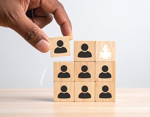 Hand placing block with person icon on stacked wooden cubes