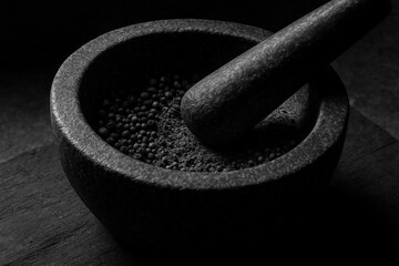Black and White Stone Mortar and Pestle: A dramatic monochrome composition reveals a rough stone mortar and pestle, filled with aromatic spices, showcasing the textures, shadows.