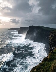 Dramatic coastal cliffs under a cloudy, stormy sky with crashing waves