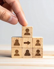 Hand places block on pyramid of wooden cubes