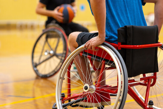 two wheelchairs with basketball players and a ball