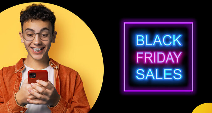 Black Friday Sale banner ad concept - happy young man in braces, eyewear glasses, typing text gazing read cell phone cellular smartphone cellphone, isolate yellow background. Mockup template design - Powered by Adobe
