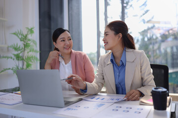 Obraz premium Two businesswoman working with business financial graph data and marketing plan at desk in office, Business concept.