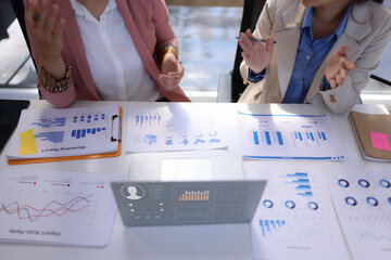 Two businesswoman working with business financial graph data and marketing plan at desk in office, Business concept.