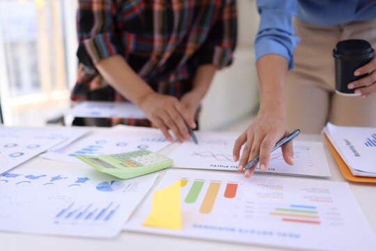 Business person hands working with business financial graph data and marketing plan at desk in office, Business people meeting explaining and business concept.