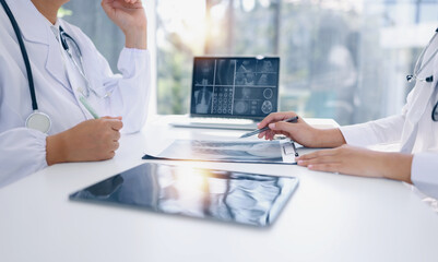 Two medical doctors working on laptop with tablet and x-ray film scan in clinic office, Medical...