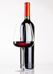 Fototapeta premium Red wine bottle and glass on white background