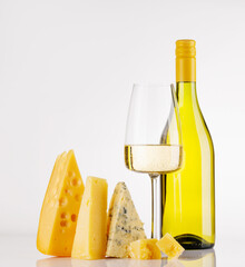 Fototapeta premium Assorted cheeses and wine on white background