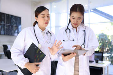 Two medical doctors woman checking the patient papers in  hospital, Medical technology and Healthcare concept. 