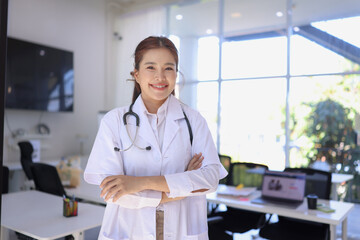 portrait of a smiling female doctor standing with arms crossed, medical and health care.