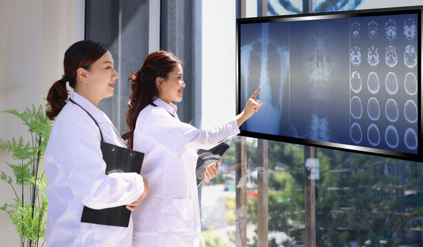 Two professional female doctor working with human anatomy virtual interface icons. Medical technology and Healthcare concept. 