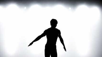 Silhouette of a dancer performing dynamic leaps and poses against a bright, backlit background.