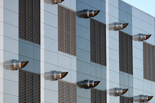 Close-up view of exterior exhaust vents and louvered panels on a modern data center, highlighting cooling and ventilation systems in large-scale digital infrastructure facilities