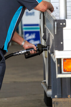 Man at fuel pump filling ute with diesel.