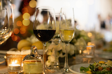 Red and white wine glasses on a beautifully set table, Fine dining and wine, Luxury table setting.