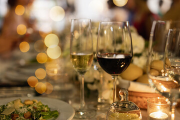 Red and white wine glasses on a beautifully set table, Fine dining and wine, Luxury table setting.
