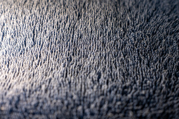 Extreme close-up of a soft blue terry cloth fabric. The detailed macro shot reveals the fibrous texture and loops, creating an abstract background with selective focus.