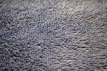 Extreme close-up of a blue fabric surface. The detailed, fibrous texture with selective focus creates a soft and abstract background for design or text.