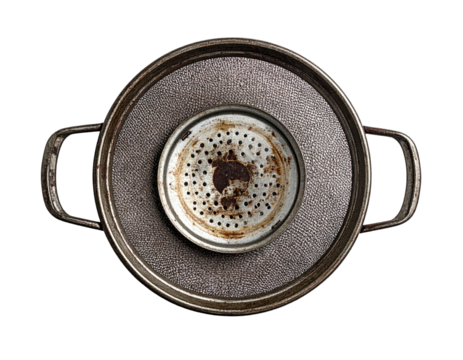 Overhead view of a rusty strainer centered within a textured metal pot and tray