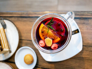 Warm drink with garnish and cookie, Cozy hot drink presented with fruit and herbs on table