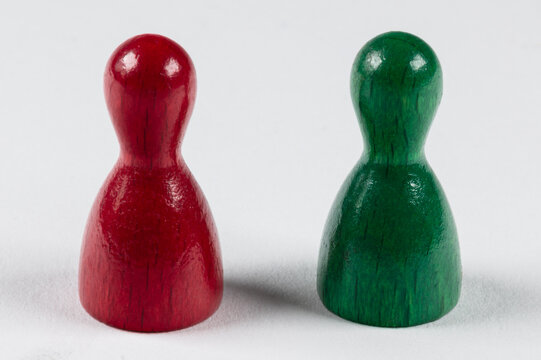 two wooden game pieces in green and red