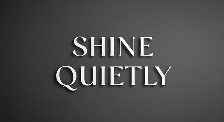 A minimalist black wall features the inspirational phrase 'SHINE QUIETLY' in large, bold, white 3D letters that create a calm and motivating atmosphere