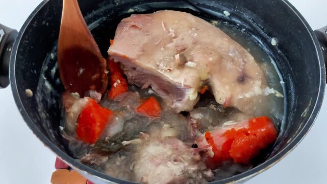 Chilled pork knuckle set in clear gelatin, with vibrant carrot slices suspended throughout. A classic savory aspic showcasing texture, color, and traditional prep in every frame