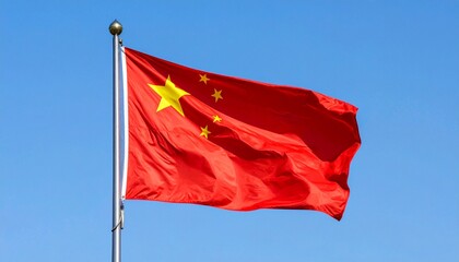 Chinese national flag waving on flagpole against clear blue sky showcasing national symbolism and cultural identity