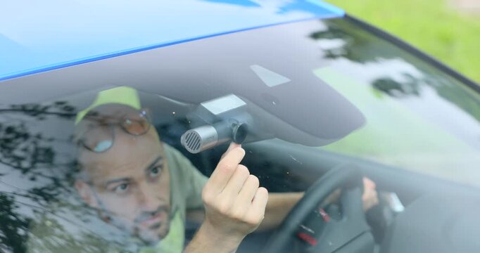 A Man Inside His Car Setting Up And Checking The Dash Camera. Close-up Shot