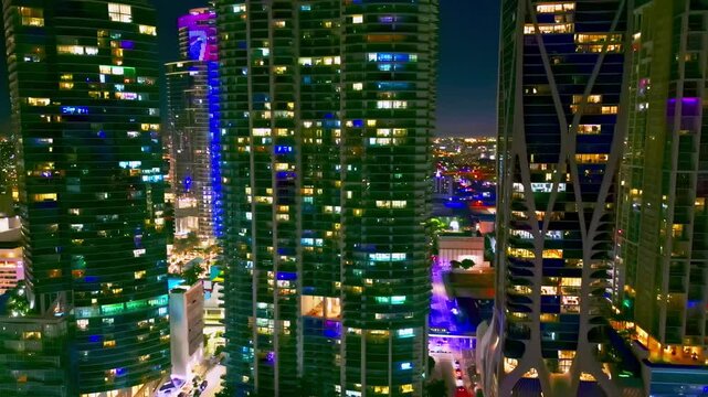 Night lights Miami tall buildings. Miami skyline glass towers. Windows in skyscrapers in night. The drone flies above the Miami city center. Miami downtown at night.