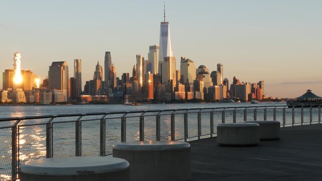 New York City Manhattan Downtown Financial District skyline, World Trade Center tower from New Jersey, Hoboken pier, United States. River waterfront urban cityscape, sunset with skyscraper building.