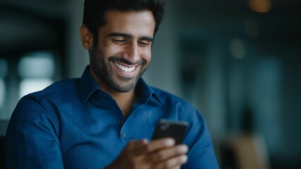 Happy young man enjoying smartphone use in modern workspace, positive lifestyle and technology theme