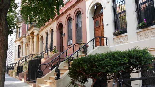 New York City townhouse buildings, brownstone row houses in Manhattan or Brooklyn, United States of America. Classic buildings on residential district street. Real estate property. Rowhouse townhome.