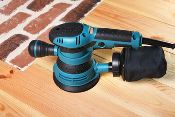 A new random orbit sander sits on the floor of the house.