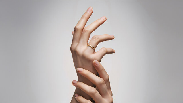 Elegant womans hands with minimalistic gold ring on a clean back