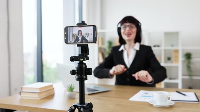 Caucasian woman at workspace recording blog about relaxation techniques, dancing, listening music.