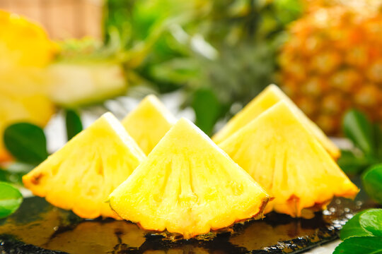 Fresh Pineapple Slices from Xuwen Zhanjiang Display on Slate with Green Leaves
